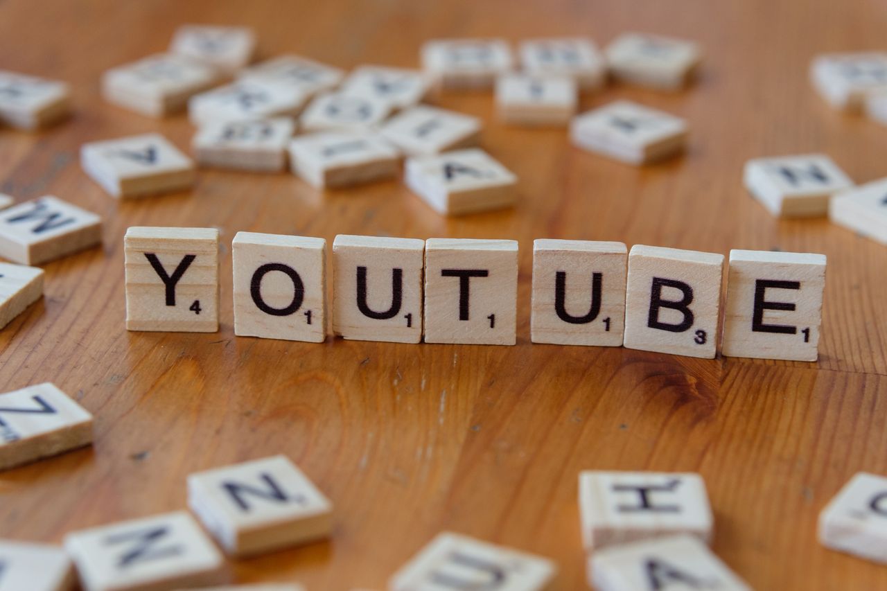 services-01 Wooden letter tiles spelling YOUTUBE on a wooden surface, symbolizing video sharing and streaming.